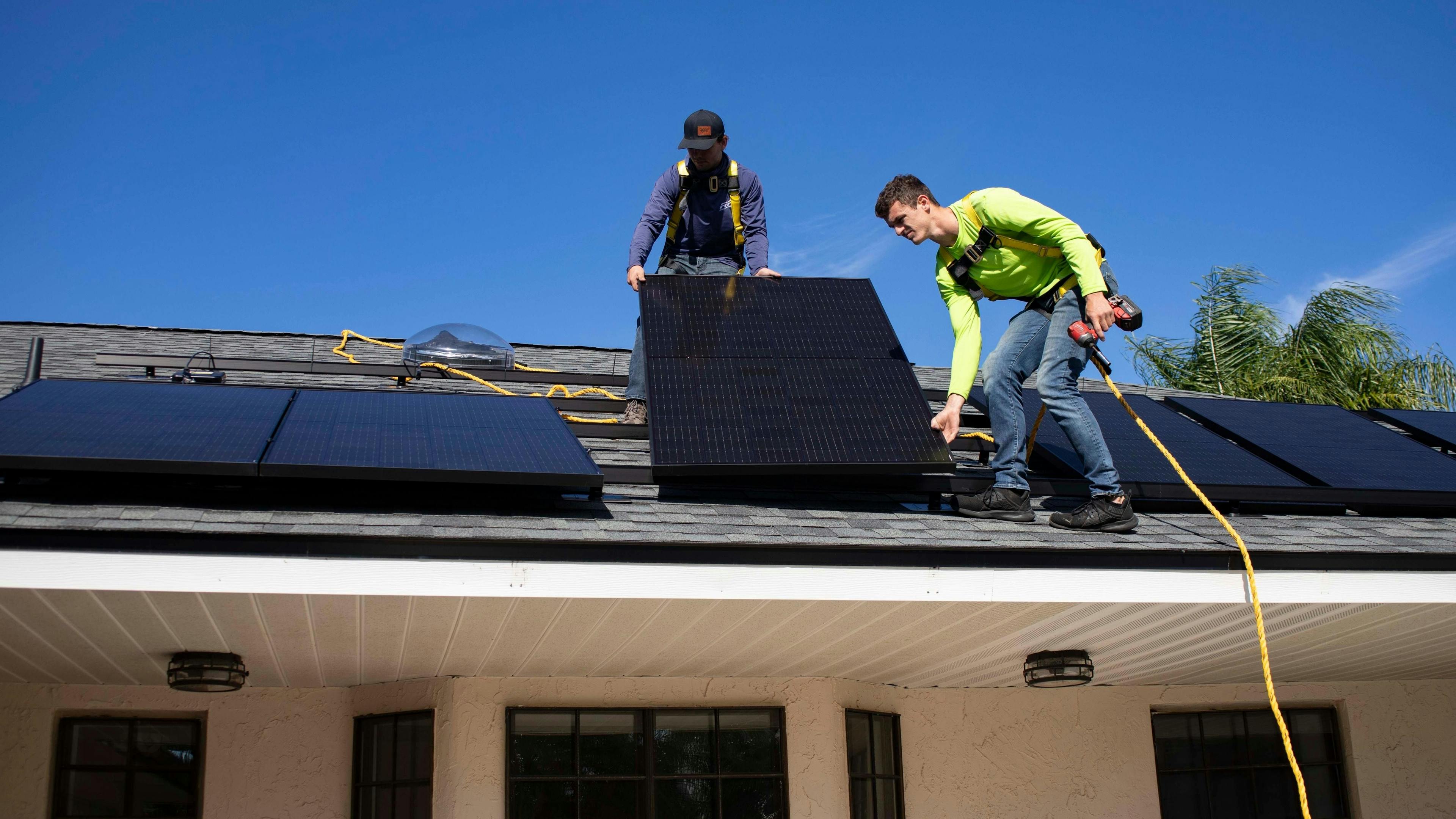 Ouvriers installant des panneaux solaires sur un toit