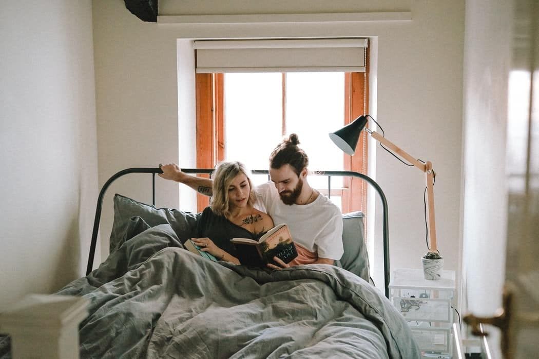 couple lisant un livre dans un lit
