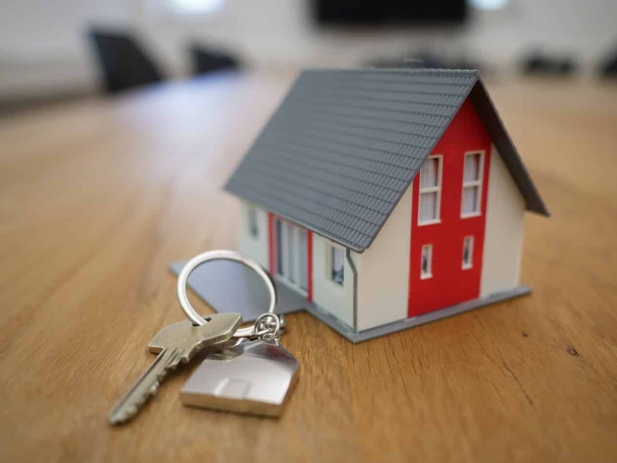 clé de maison devant une maison miniature